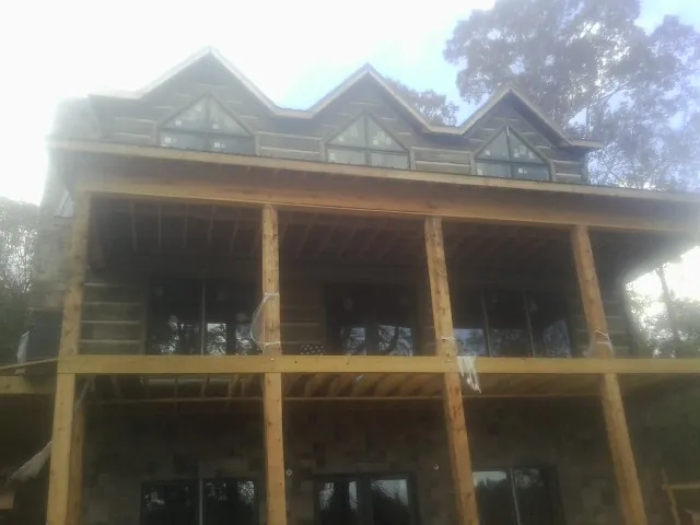 Dormers and porch framing on a large log home under construction — Roof Coating work by our crew in Nicasio