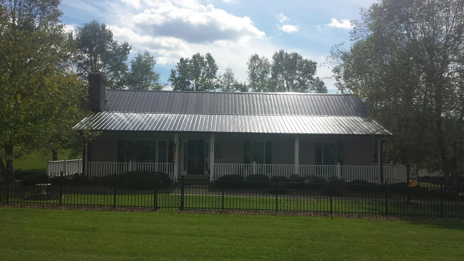 Gray metal roof on a brick ranch with a full width front porch — Gutter Guard Installation work by our crew in Nicasio